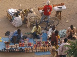 Hier werden Schuhe aus Kunststoff und aus Leder verkauft, in der Reihe dahinter gibt es Kolanüsse und getrocknetes Fleisch.
