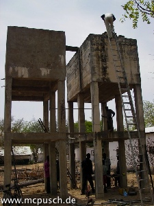 Zwei Wassertürme aus Beton stehen Seite an Seite.